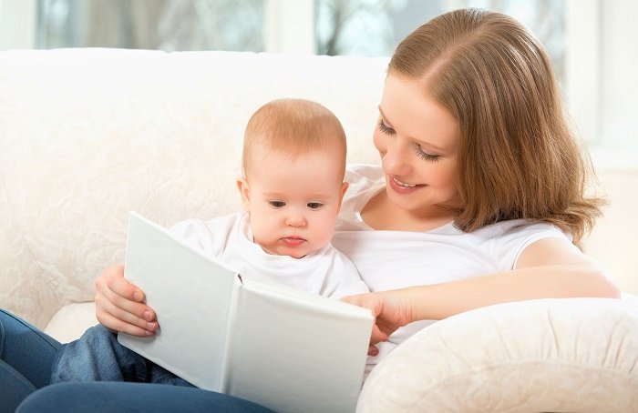 mẹ đọc sách cho bé trên ghế sofa trắng