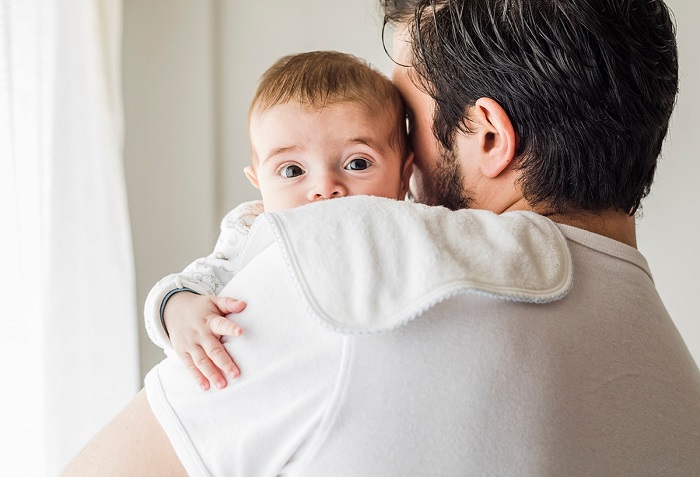 Em bé được bố mẹ ôm ấp.